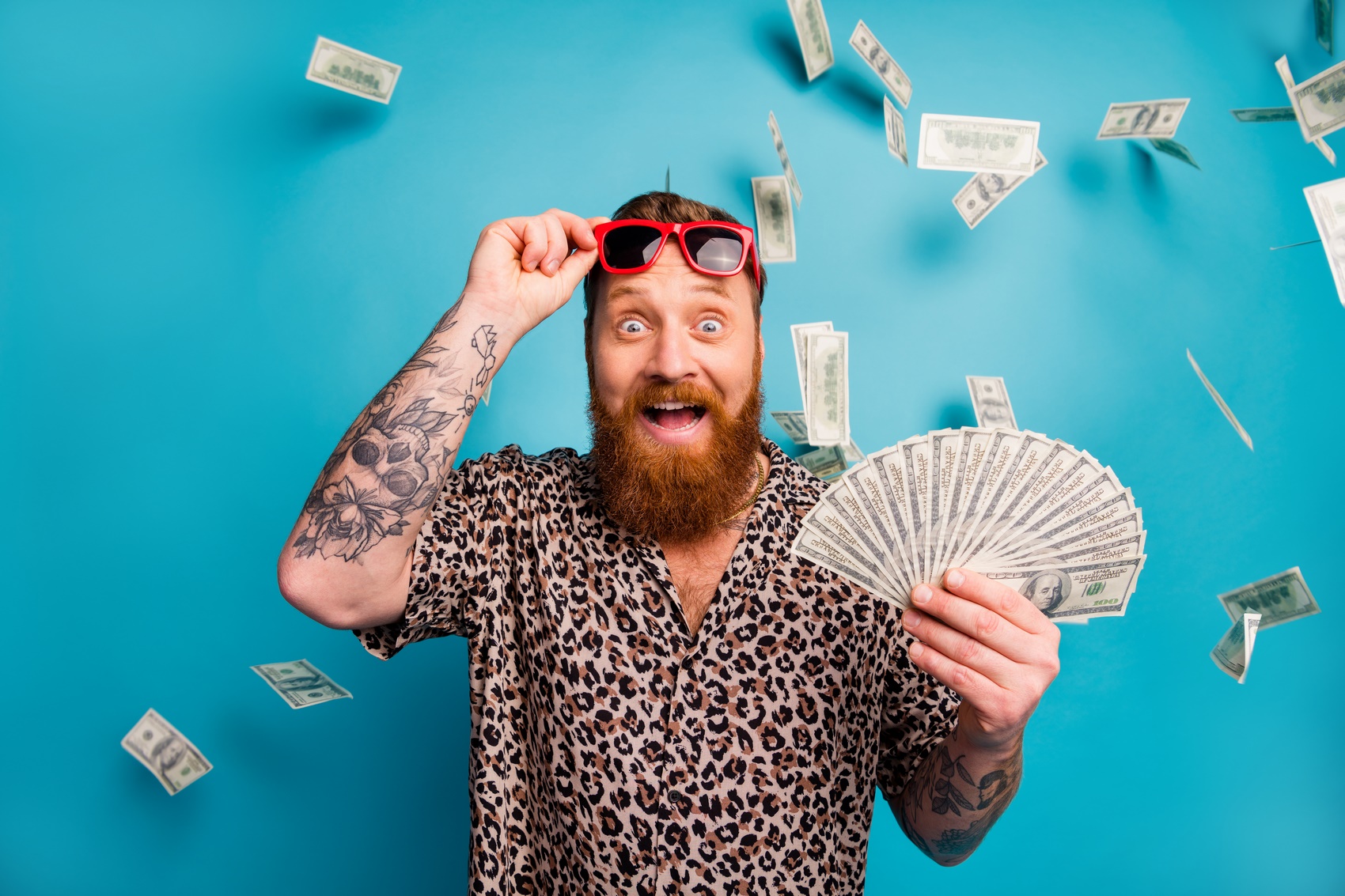 Mężczyzna w koszuli i okularach trzymający pieniadze